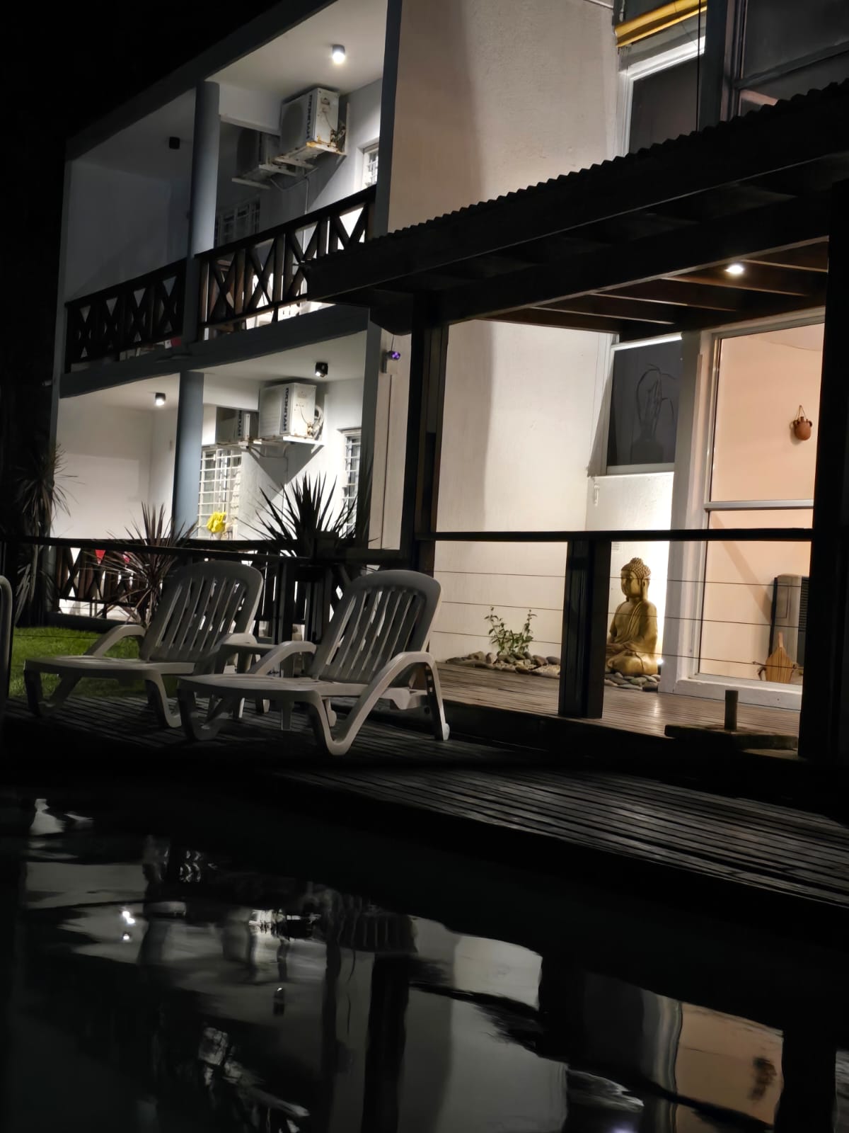 Deck de madera junto a la piscina, de noche